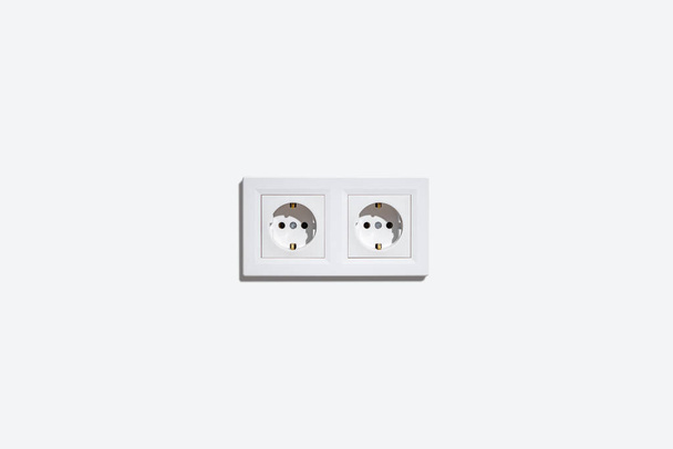 Deux prises dans un cadre blanc sur un mur blanc - Photo, image