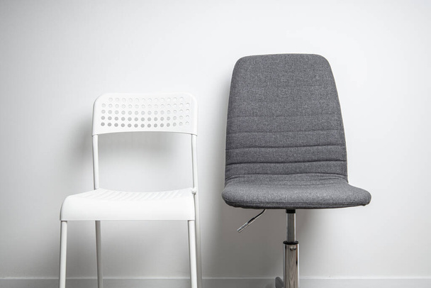 Silla de plástico blanco, silla de oficina de tela sobre fondo de pared blanco - Foto, Imagen