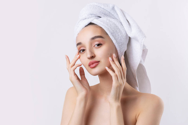 Beautiful girl with thick eyebrows and perfect skin at white background, towel on head, beauty photo. - Фото, изображение