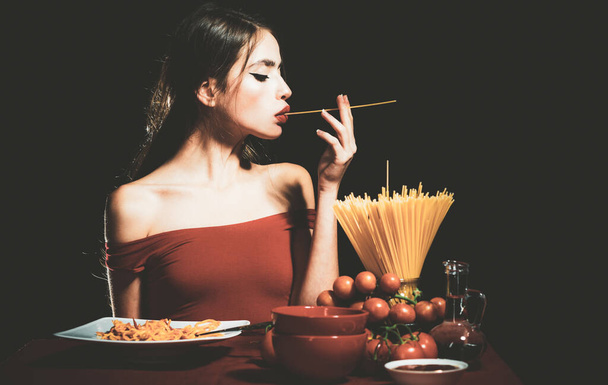 Beautiful young woman with noodles spaghetti, sexy kitchen. - Φωτογραφία, εικόνα