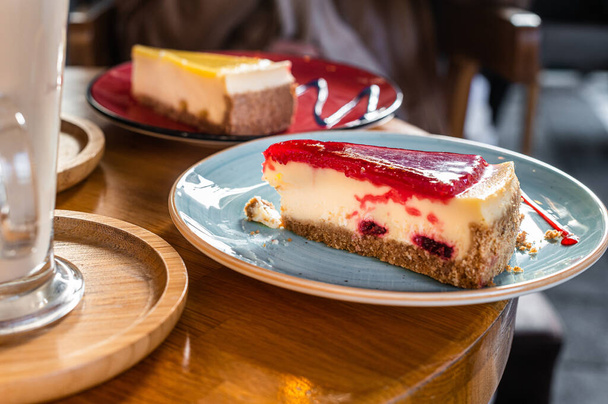 Κλασικές φράουλες Νέας Υόρκης και cheesecake λεμόνι σε ένα ξύλινο τραπέζι στο καφέ. Άνω όψη - Φωτογραφία, εικόνα