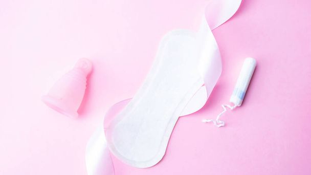 Almofadas menstruais, copo de menstruação e tampão para a higiene da mulher em fundo rosa. Menstruação período feminino. Flat lay banner, espaço de cópia para texto. Cuidados ginecológicos - Foto, Imagem