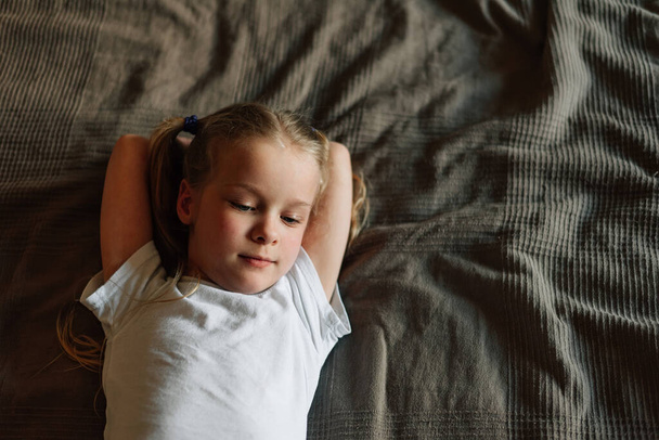 портрет ребенка лежит на кровати дома. Высокое качество фото - Фото, изображение