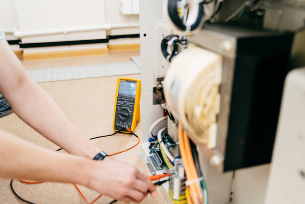 the engineer measures the voltage in the electrical appliance. - Foto, Bild
