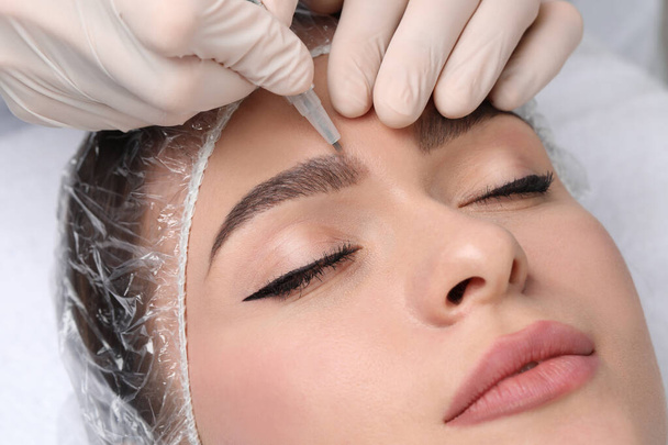 Young woman during procedure of permanent eyebrow makeup, closeup - Fotoğraf, Görsel