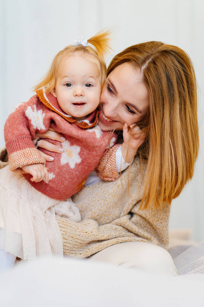 Cute mom and baby daughter play and hug. games with children.  - 写真・画像
