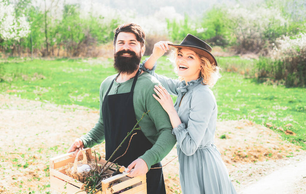 Cheerful couple of farmers standing in vegetable garden. Smile Couple on farmland. I like spending time on farm. Crop planting at fields. - Foto, imagen