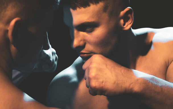 Close up portrait of two muscular men fighting, punching each other, boxing or mma. - Photo, image