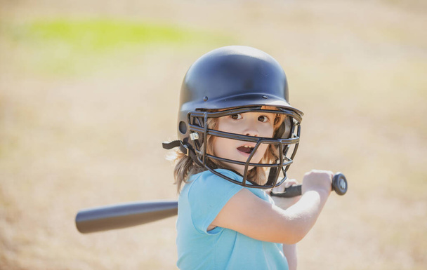 Little blond boy with a expression on face holds a baseball bat. - 写真・画像