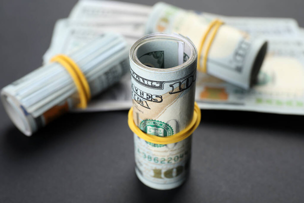 Rolled dollar banknotes on black background, closeup. American national currency - Φωτογραφία, εικόνα