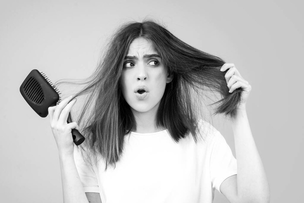 Sad girl with damaged hair. Hair loss problem treatment. Portrait of woman with a comb and problem hair. - Φωτογραφία, εικόνα