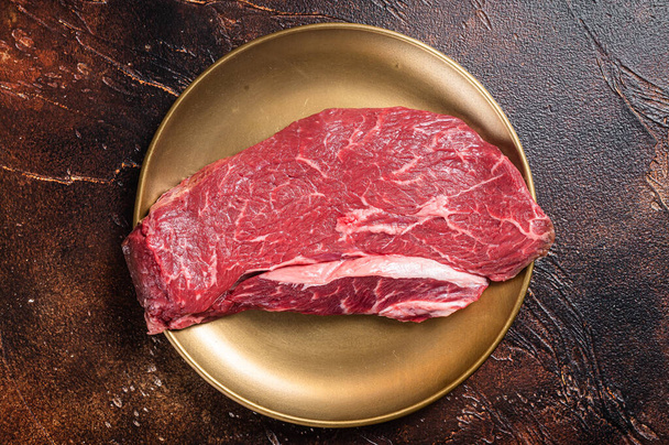 Мармуровий первинний яловичий стейк, сирий верхній сироїдний м'ясний стейк. Темний фон. Вид зверху
 - Фото, зображення