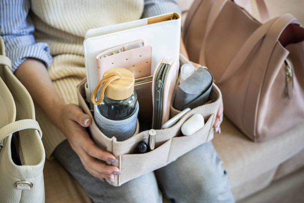 Close up woman hands holding comfortable removable felt organizer for personal accessories storage - Fotografie, Obrázek