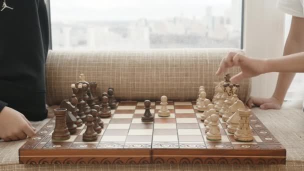 Una partida de ajedrez. Creativo. Un tablero de ajedrez con piezas blancas y negras y dos personas jugando. - Metraje, vídeo