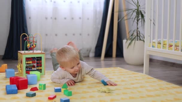 carino bambino giocare con i blocchi nella stanza dei bambini - Filmati, video
