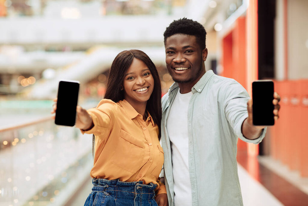 Black couple showing blank empty smartphone screen for mockup - Фото, изображение