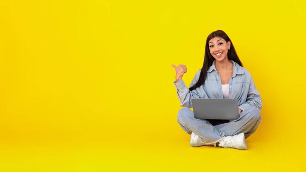 Щаслива леді, використовуючи ноутбук, що вказує в сторону на студії
 - Фото, зображення