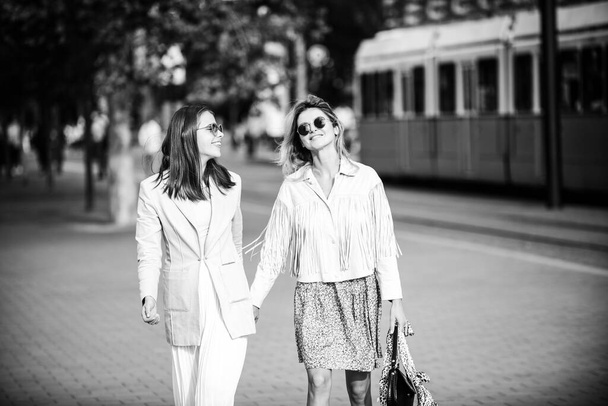 Exited hipster girls friends spending great time together in city. Funny vacation, romantic travel. Best female friends having fun and walking in the street. - Foto, imagen