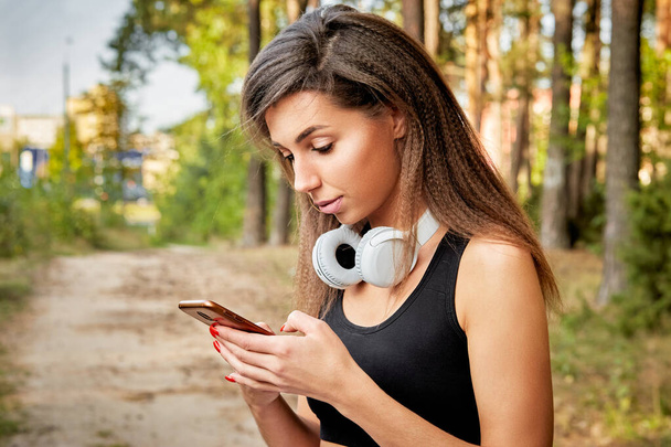 young woman with a phone in the park for a walk - Photo, image