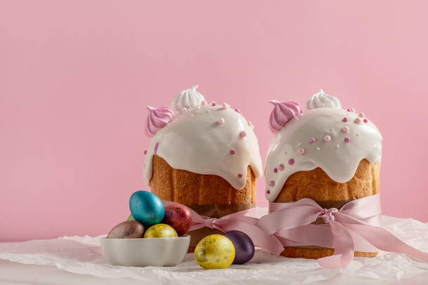 Ciasta wielkanocne, tradycyjne wielobarwne jajka na świątecznym stole, na różowym tle - Zdjęcie, obraz