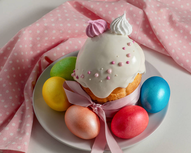 Osterkuchen, die traditionellen bunten Eier und pinkfarbenes Tuch auf dem Festtagstisch - Foto, Bild
