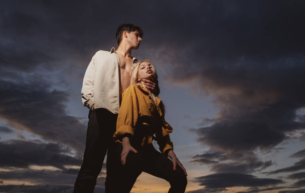 Sensual portrait of young couple in love. Loving couple embracing and kissing on dramatic sky. - Foto, Imagen