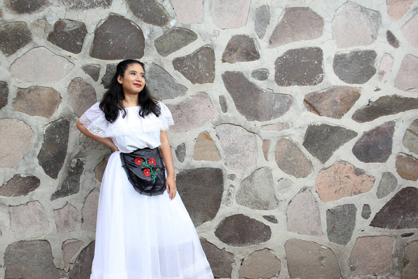 Junge Frau aus Veracruz trägt stolz und glücklich ein traditionelles mexikanisches weißes Kleid mit nackten Schultern und schwarzer Schürze als Teil der Kultur, des Tanzes und der Wurzeln Mexikos - Foto, Bild