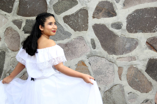 Junge Frau aus Veracruz trägt stolz und glücklich ein traditionelles mexikanisches weißes Kleid mit nackten Schultern und schwarzer Schürze als Teil der Kultur, des Tanzes und der Wurzeln Mexikos - Foto, Bild