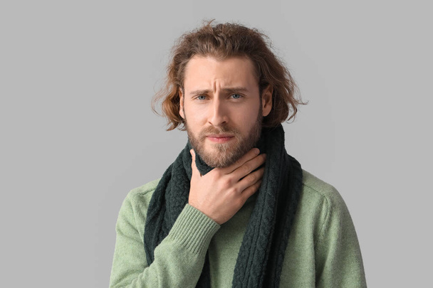 Homem com dor de garganta no fundo cinza - Foto, Imagem