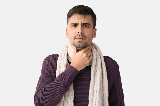 Ill young man with sore throat on white background - Photo, Image
