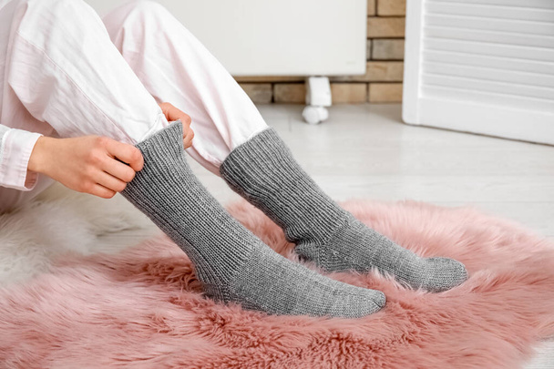 Woman wearing warm socks on fluffy rug. Concept of heating season - Fotografie, Obrázek