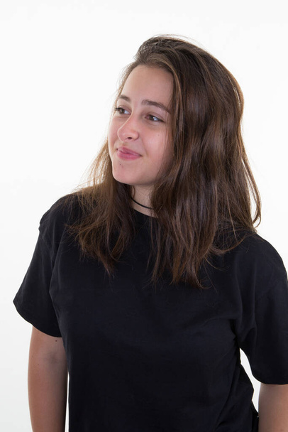 молода жінка брюнетка довге волосся дивиться ліворуч прямо на білому тлі
 - Фото, зображення