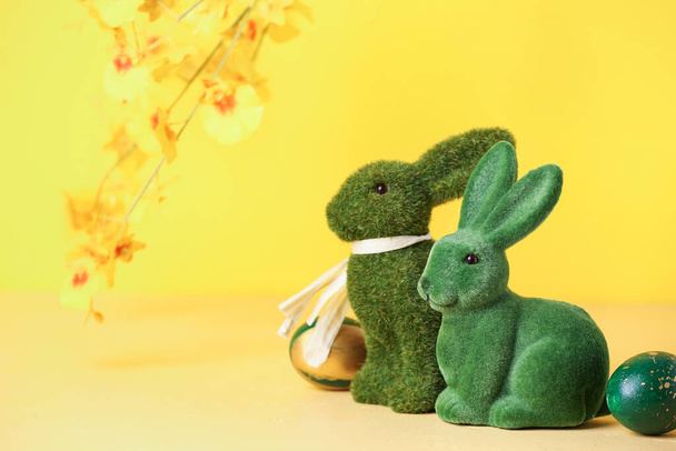 Green Easter bunnies and eggs on yellow background - Photo, Image