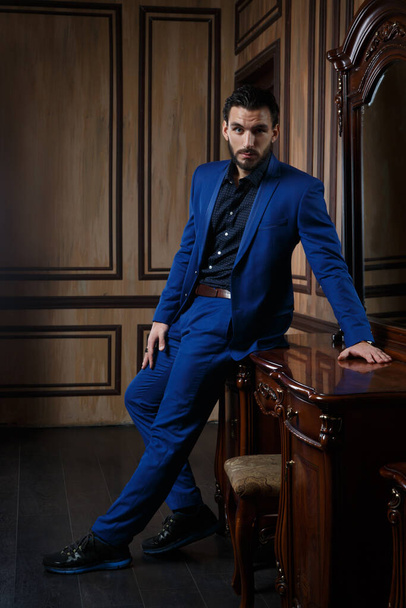 Attractive man in an elegant blue suit in a classic interior. - Фото, зображення