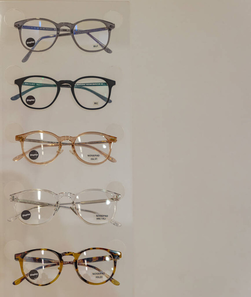 Трендовые стильные очки на бежевом фоне копируют пространство для текста, оптики, магазина очков и концепта, никто - февраль 2021 года, Ванкувер, Канада. проверка зрения, осмотр зрения у оптика - Фото, изображение