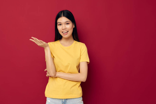 Portret Azjatki piękna młoda kobieta w żółtym t-shirt gestykulując rękami zabawy odizolowane tło bez zmian - Zdjęcie, obraz
