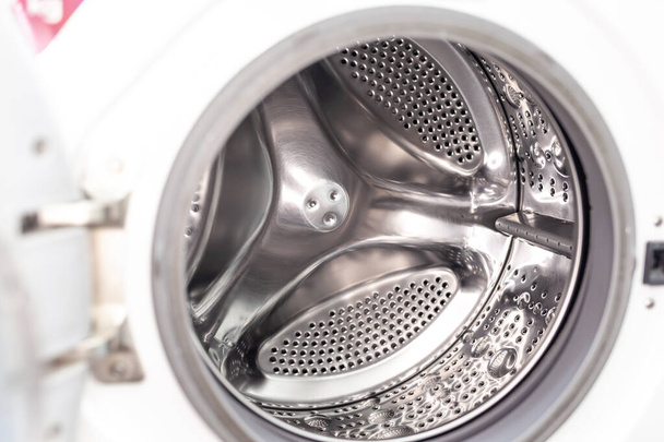 The washing machine drum is dry and clean close-up. Washer - 写真・画像