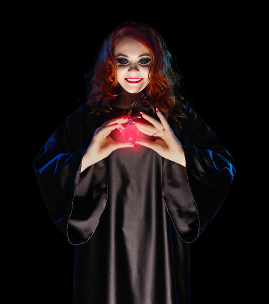 Young witch with red potion isolated - Foto, imagen