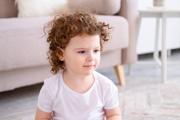 portré aranyos göndör mosolygós gyermek lány barna szeme otthon - Fotó, kép