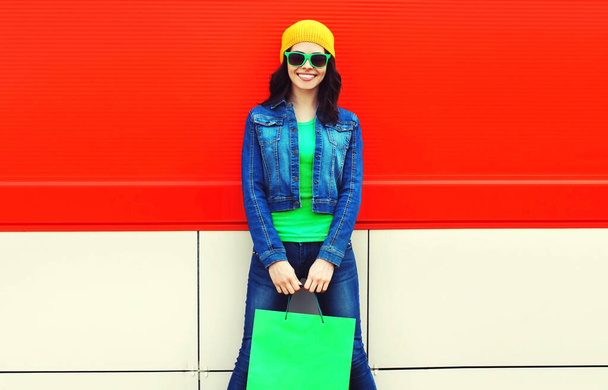 Portrait of beautiful happy smiling young woman with shopping bags on colorful background - Фото, зображення