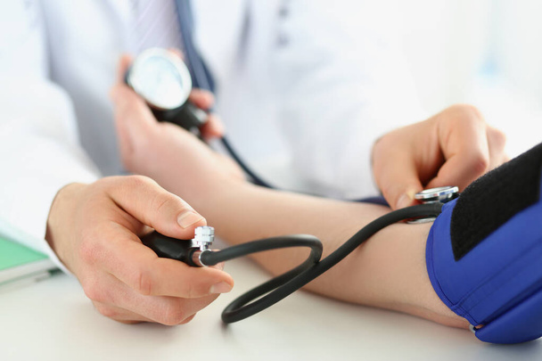 Médico verificar a pressão arterial do paciente na clínica, risco de hipertensão, prevenir a doença - Foto, Imagem