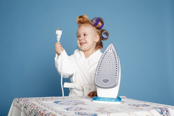 little housewife with iron on blue background - Photo, image