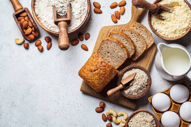 Keto bread cooking. Different types of nut flour - almond, hazelnut, cashew and baking ingredients, dark background, top view. Gluten free concept. - 写真・画像