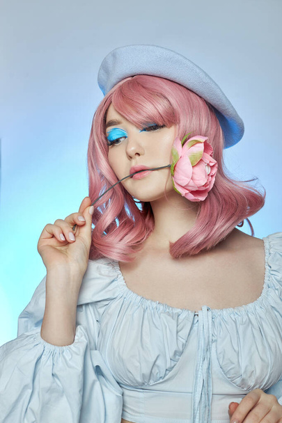 Romantic woman with pink hair in a blue beret on her head, a French woman with a rose in her hands. Blue makeup on the eyes eyelids of a young woman - Foto, immagini