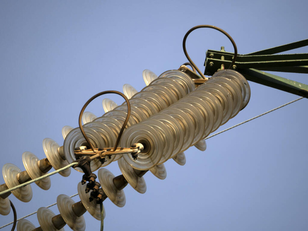 Wysokonapięciowe przewody elektryczne czapki i pin szczegółowo izolatora na niebieskim niebie - Zdjęcie, obraz