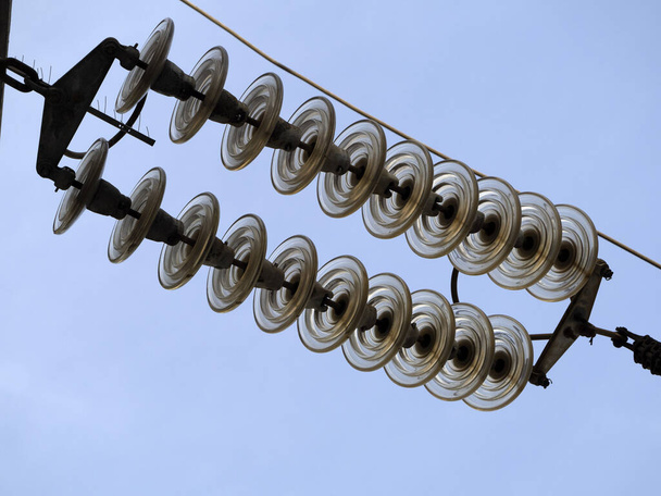 Ηλεκτρικό κάλυμμα καλωδίων υψηλής τάσης και λεπτομέρεια μονωτή ακίδων στον μπλε ουρανό - Φωτογραφία, εικόνα