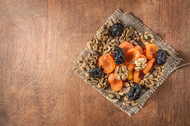 nuts and other fruits on a wooden background - Photo, Image