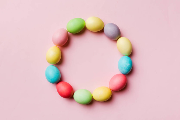 round frame Multi colors Easter eggs on colored background . Pastel color Easter eggs holiday concept with empty space for you design. - Foto, afbeelding