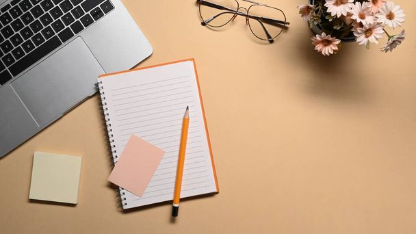 Empty notebook, eye glasses and flower pot on beige background. - Φωτογραφία, εικόνα