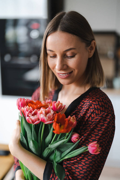Jovem mulher gosta de flores em casa - Foto, Imagem